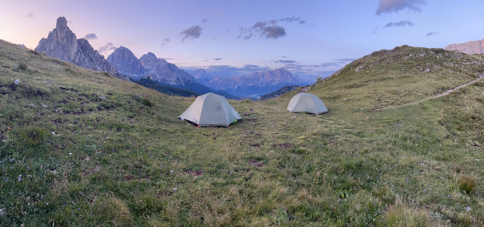Two backpacking tents pitched in the Dolomites at sunset.